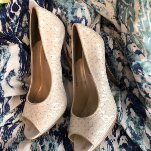 White laced heels with silver studs.